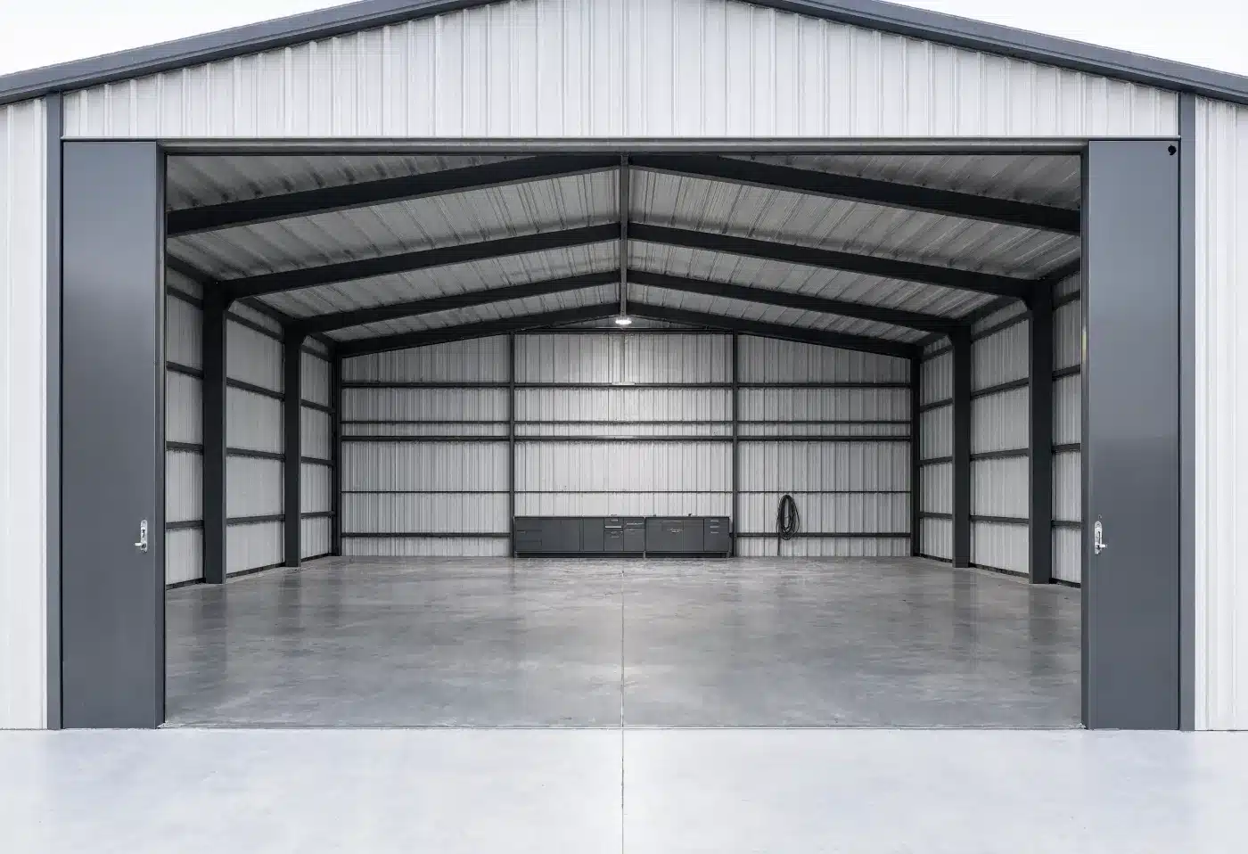 An empty hangar bay with the bifold door raised and a clean sealed concrete floor