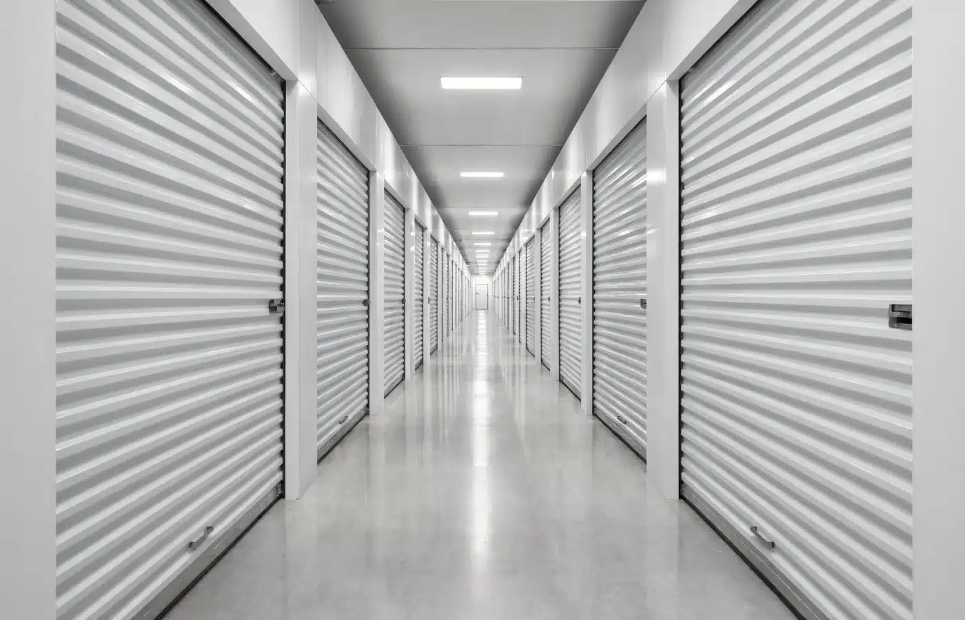 An interior climate-controlled storage hallway with roll-up unit doors on both sides